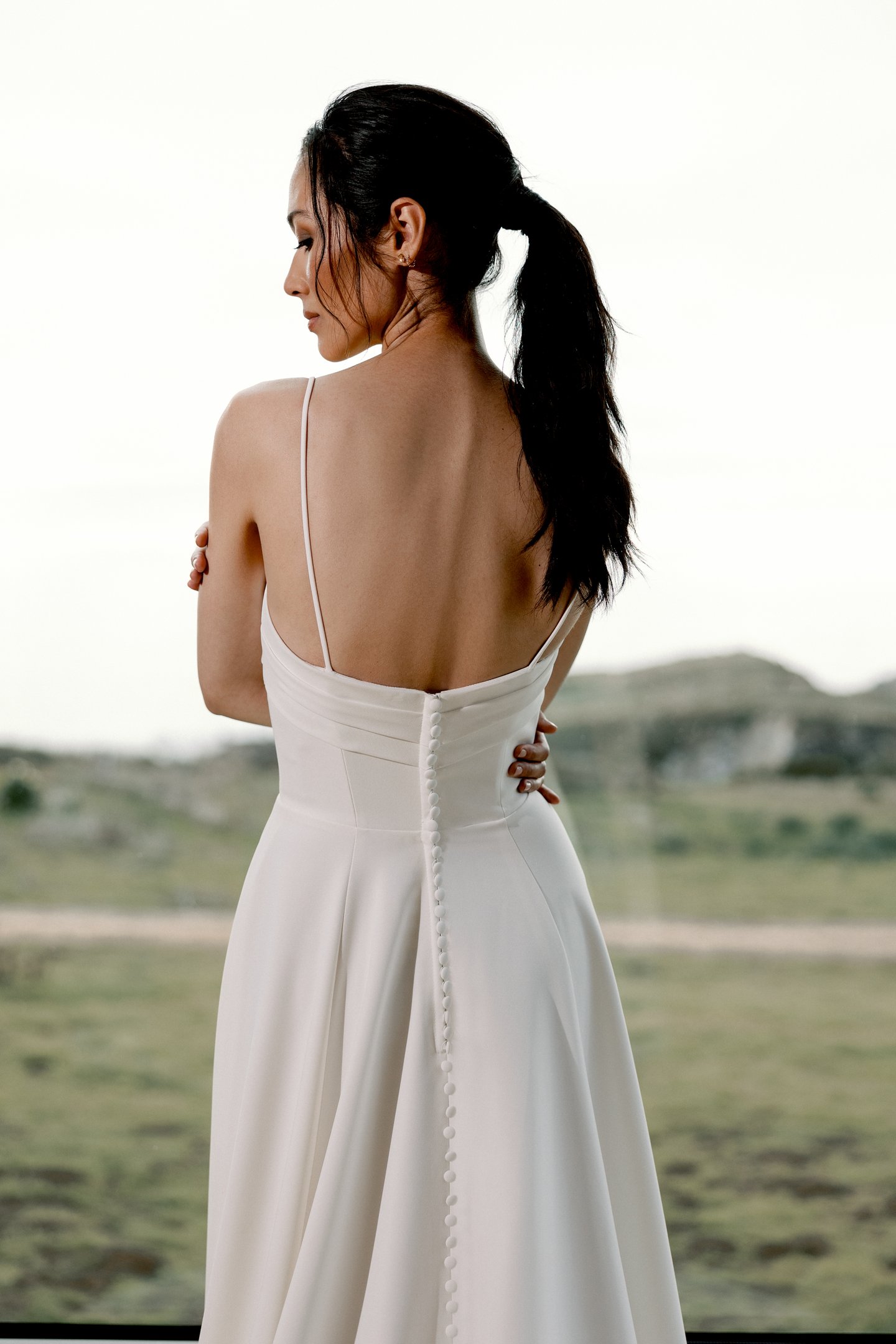 Adore by Justin Alexander Style 11413 Sereia Clean Crepe A-Line Gown with Twisted Bikini Neckline and Pockets Cut-Out Detail