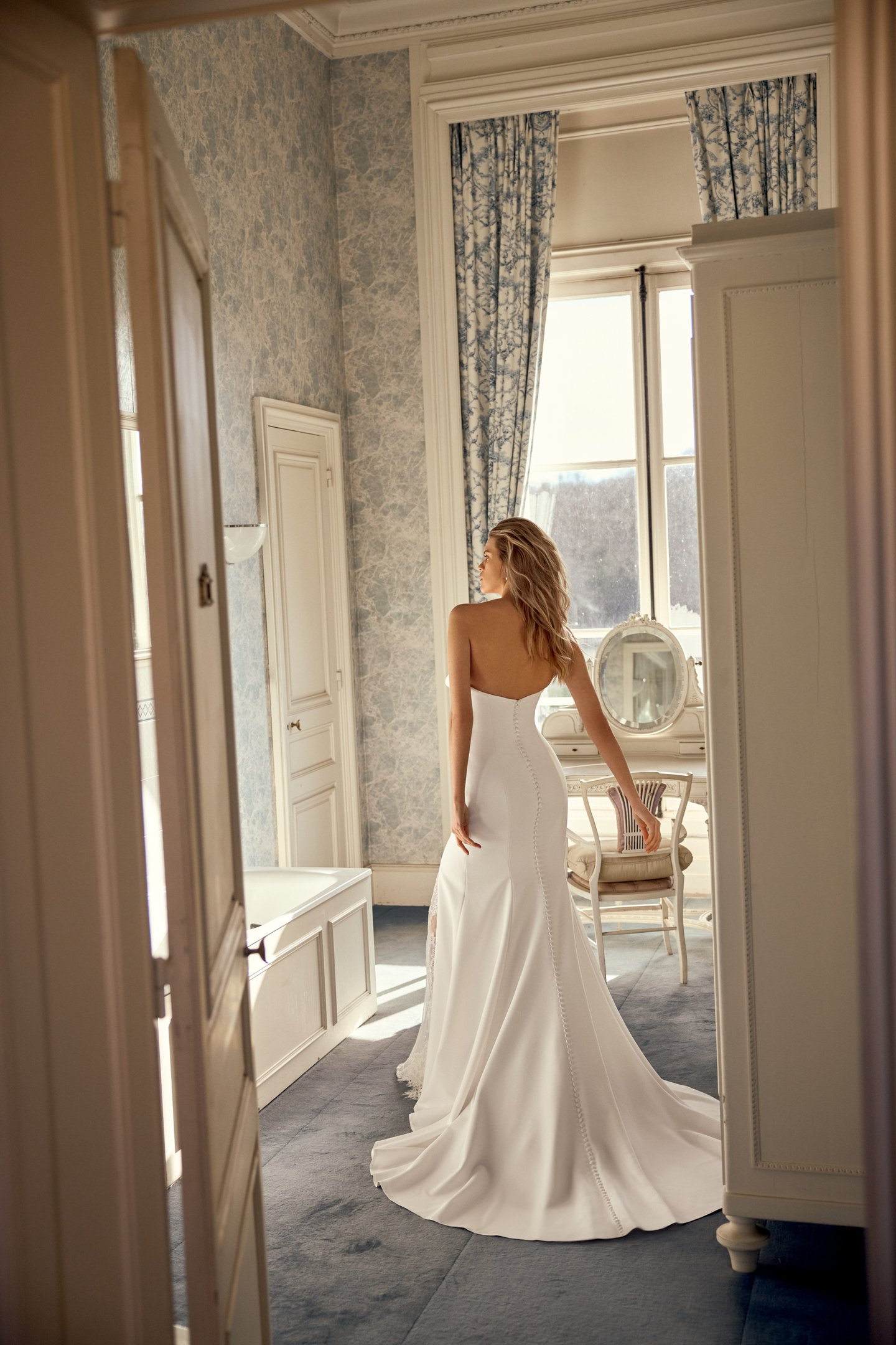 Justin Alexander Style 88544 Noryn Strapless Crepe Fit and Flare Bridal Gown with Asymmetrical Draped Crepe on Bodice with Sultry Skirt Slit